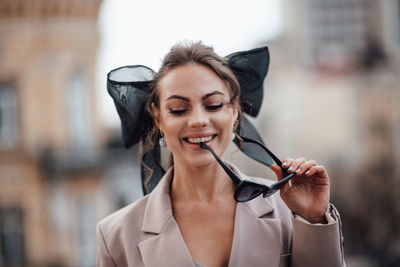 Portrait of a smiling young woman holding camera