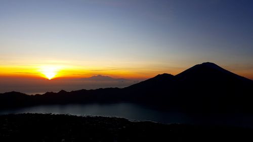 Scenic view of silhouette mountains against sky during sunset