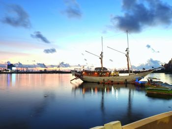 Boats moored at harbor against sky during sunset