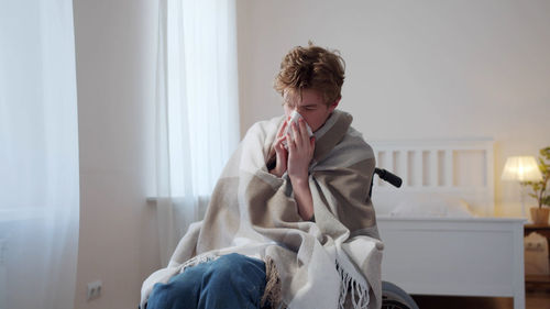 Sick man sitting on wheelchair at home