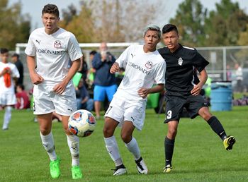 Full length of friends running on soccer field