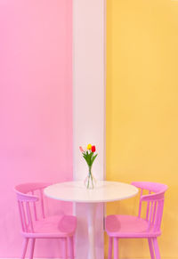 Close-up of flowers vase on table against wall