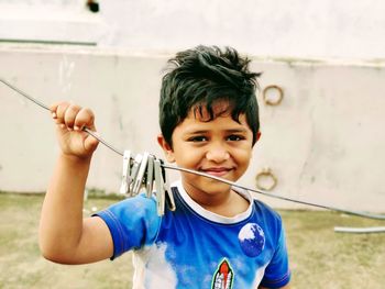 Portrait of boy holding clothesline