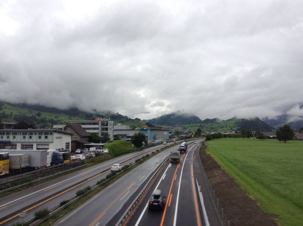 transportation, road, sky, cloud - sky, the way forward, mode of transport, land vehicle, road marking, high angle view, cloudy, car, diminishing perspective, on the move, vanishing point, highway, railroad track, travel, overcast, architecture, motion