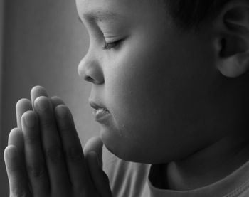 Boy praying to god on gray background with people stock image stock photo
