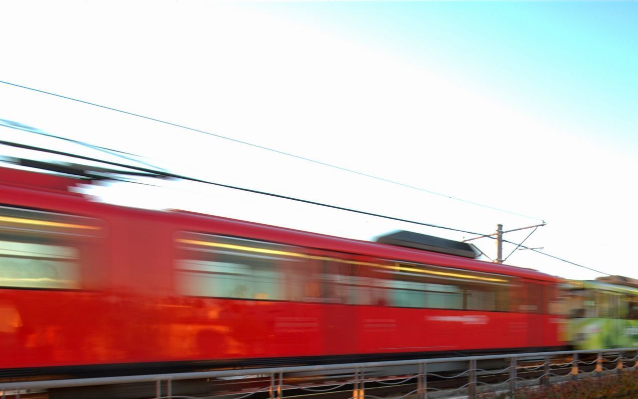 TRAIN AT RAILROAD STATION AGAINST SKY