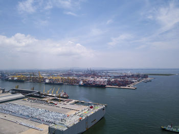 High angle view of city by sea against sky