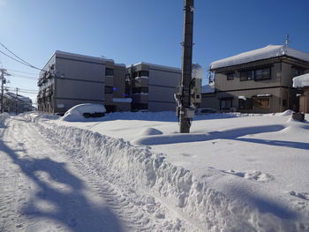 Snow covered houses against clear sky