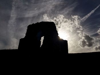 Low angle view of silhouette built structures against sky