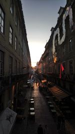 Street amidst buildings in city against sky at dusk