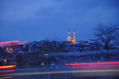 Illuminated buildings against sky at night