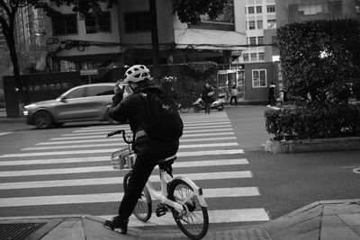 Rear view of man riding bicycle on street