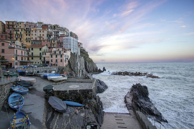 Panoramic view of sea and buildings against sky during sunset