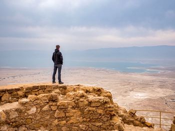 Full length of man standing on cliff against sky