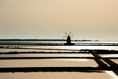 Silhouette of beach against clear sky