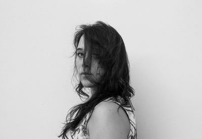 Portrait of woman standing against white background