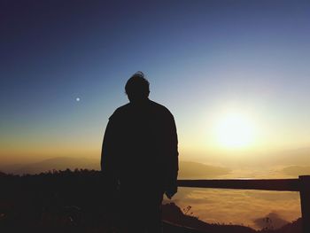 Silhouette woman standing against sky during sunset