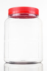 Close-up of glass of jar over white background