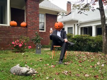 Man with pumpkin head in yard