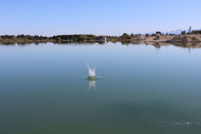 Scenic view of lake against clear blue sky