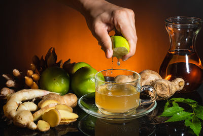 Cropped image of man holding drink on table