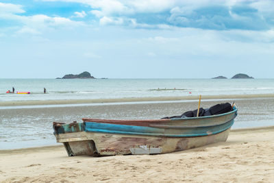 Boat moored at beach against sky