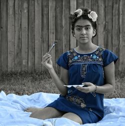 Portrait of young woman sitting on field