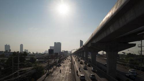 Vehicles on highway in city against sky