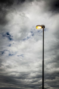 Low angle view of street light against cloudy sky