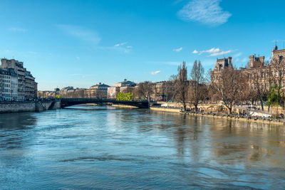 Arch bridge over river against buildings in city