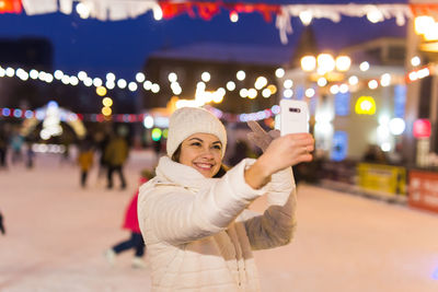 Portrait of smiling young woman standing at night