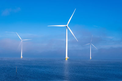 Wind turbines against blue sky