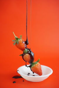 Close-up of orange fruit against red background