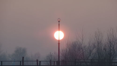 Illuminated lights against sky during sunset