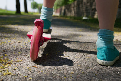 Low section of child skateboarding on footpath