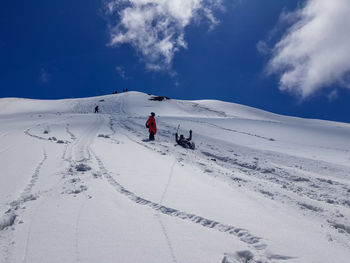 People skiing on snowcapped mountain against sky