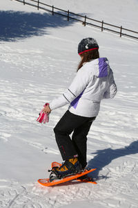 Woman snowshoeing on snowy field