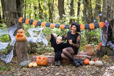 Halloween. mother with little son in halloween costumes having fun outdoor