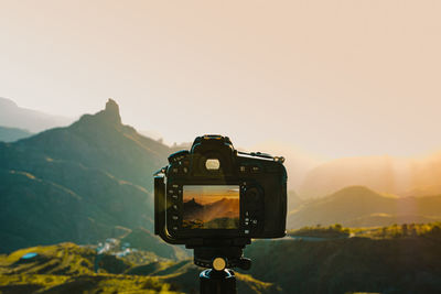 Low angle view of camera against sky during sunset