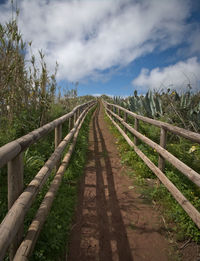 View of wooden fence on field against sky