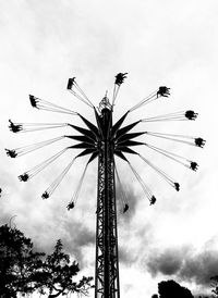 Low angle view of chain swing ride against sky