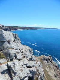 Scenic view of sea seen from cliff against sky