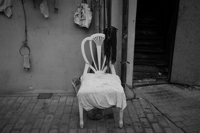 Rear view of man sitting on seat against wall