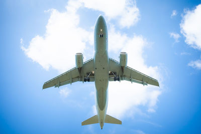 Low angle view of airplane flying against sky