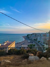 Bridge over sea by city against sky