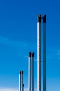 Low angle view of smoke stack against blue sky