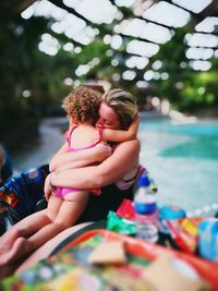 Mother embracing girl at poolside
