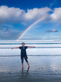 Full length of girl at beach with rainbow