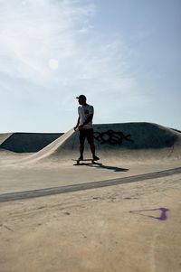 Full length of man standing on skateboard 