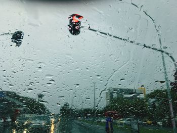 Illuminated stoplight seen through wet windshield during rainy season